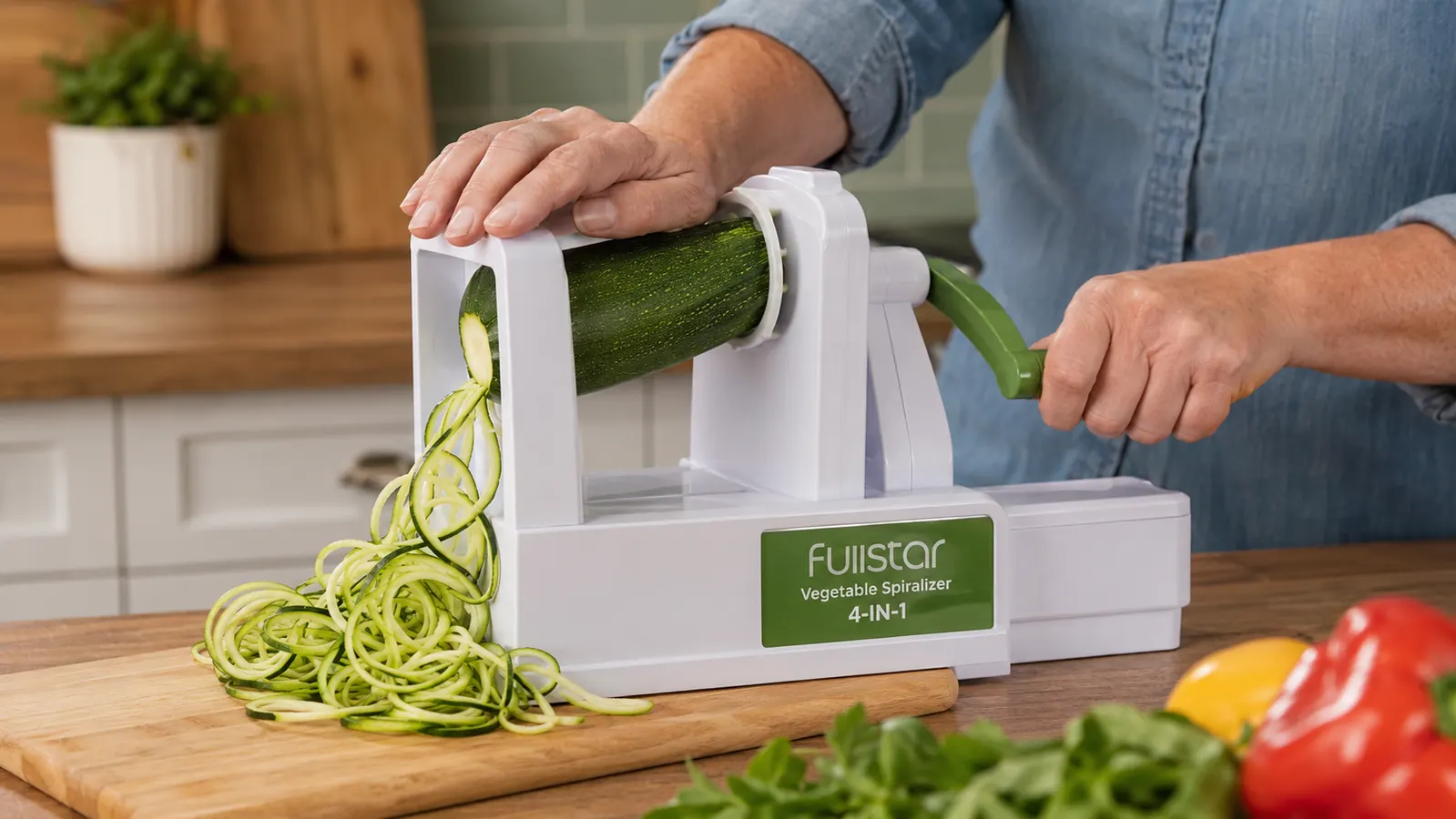 Hands pressing a whole zucchini onto the Fullstar spiralizer with the blade assembly visible